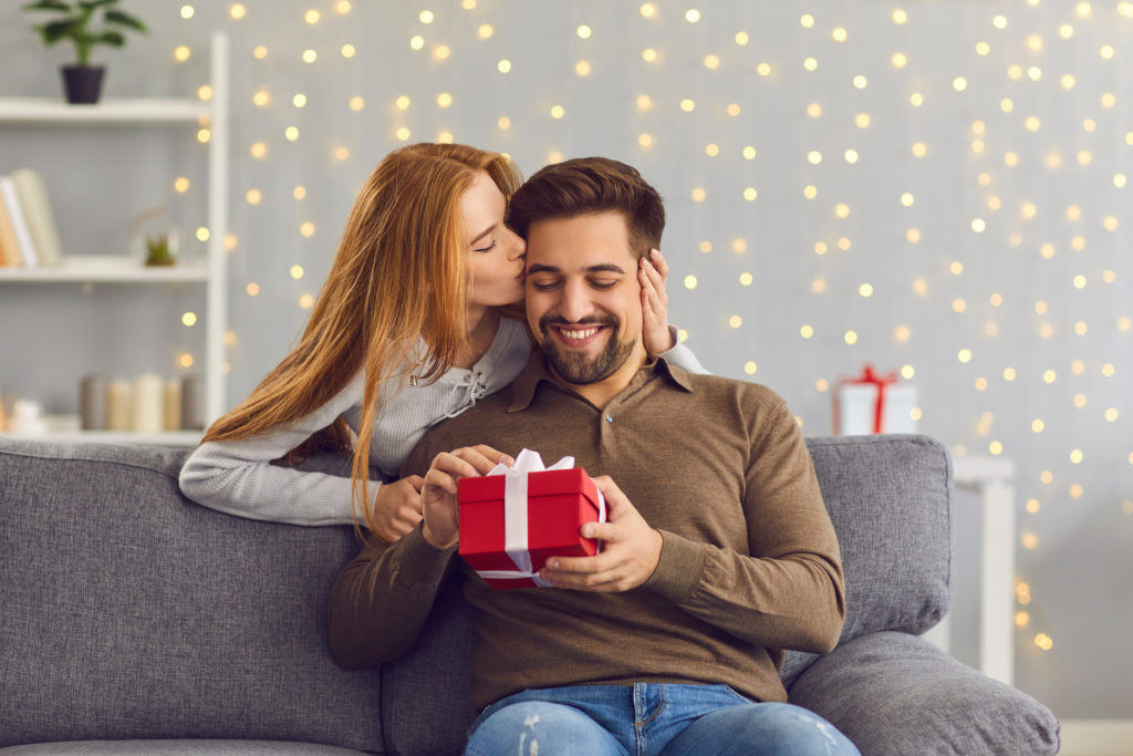 A woman giving her man a gift for the bella mansions Valentine's Day Gift Ideas blog
